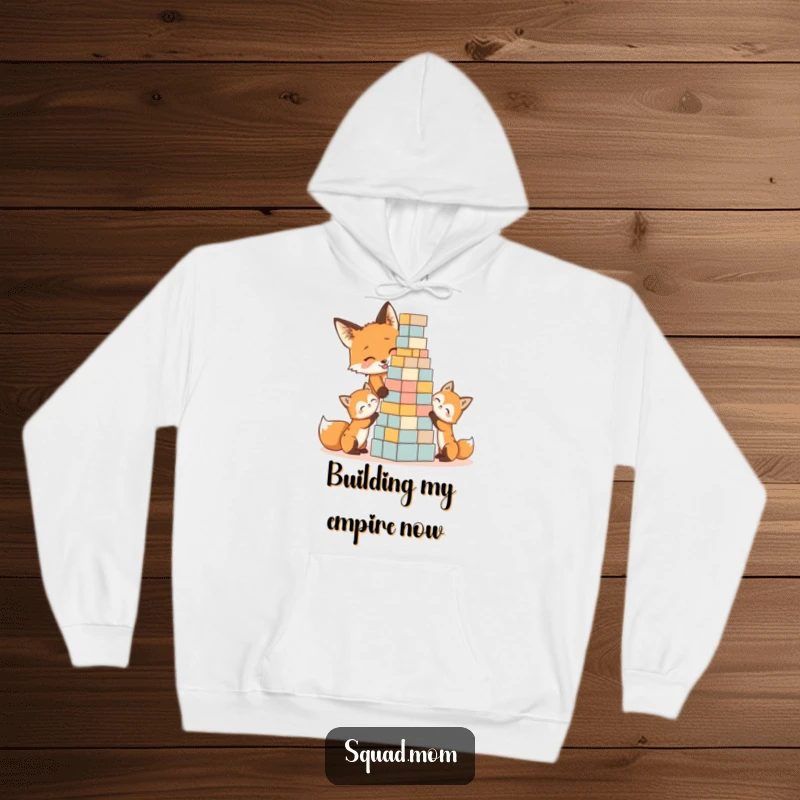 Funny and cozy hoodie featuring a fox mom and kits gleefully building a block tower, ideal for a humorous gift.